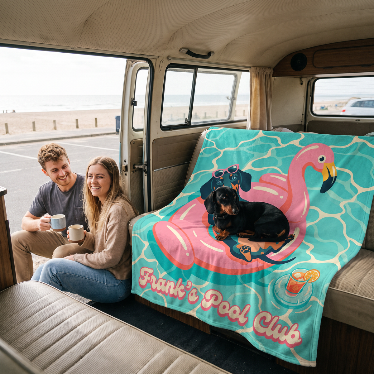 Couple in a campervan at the beach with a Pool Club pet blanket and their dachshund