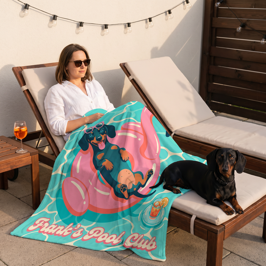 Woman on a sun lounger with a Pool Club dachshund blanket and her sausage dog